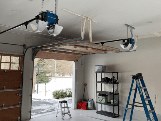 Open garage door with tracks and a ladder inside